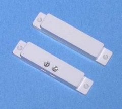 White surface mount magnetic alarm contact sensor with two rectangular components showing mounting brackets and contact poin…